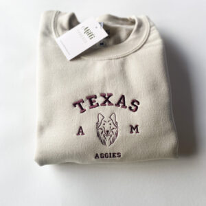 Embroidered Texas A&M and Aggies in maroon threads on sand sweatshirt.